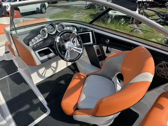 Slide: The Image of 2012 MasterCraft X-35 boat interior with orange and white seating, modern dashboard, and steering wheel. - 31