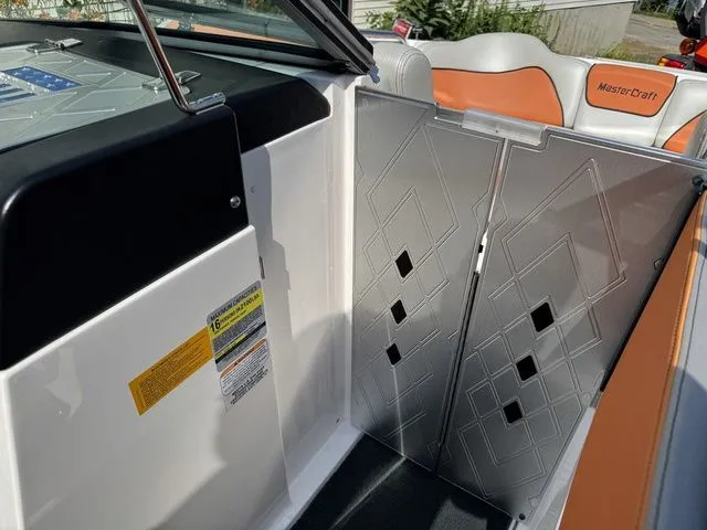 Slide: The Image of 2012 MasterCraft X-35 boat interior with geometric-patterned door and orange-accented seating. - 33