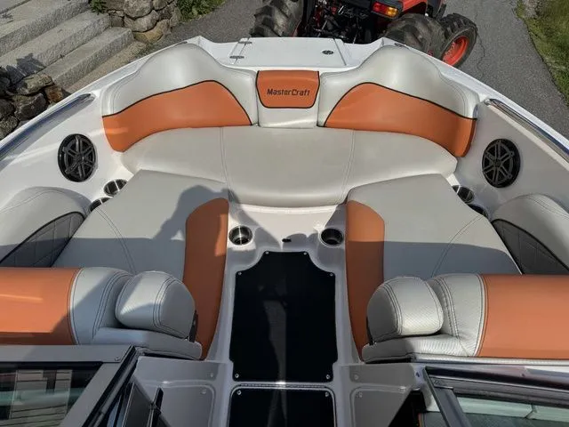 Slide: The Image of 2012 MasterCraft X-35 boat interior with orange and gray seating, cup holders, and speakers. - 34