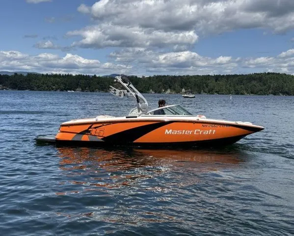 Slide: The Image of 2012 MasterCraft X-35 boat on a lake under a partly cloudy sky. - 4