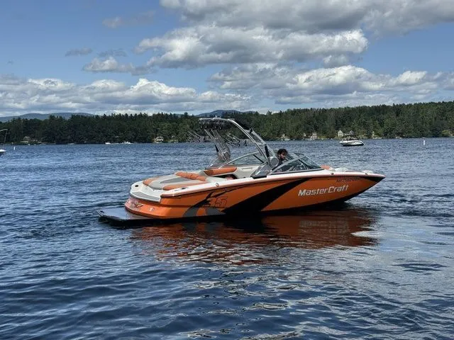 Slide: The Image of 2012 MasterCraft X-35 boat on a lake under a partly cloudy sky. - 5