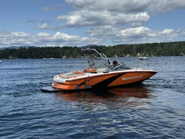 Slide: The Image of 2012 MasterCraft X-35 boat on a lake with scenic forest background. - 6