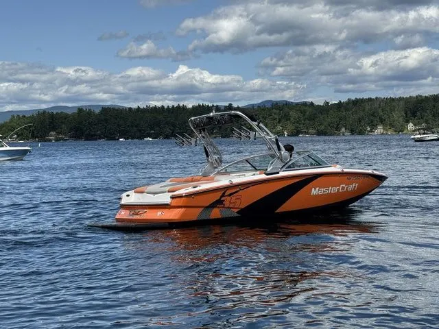 Slide: The Image of 2012 MasterCraft X-35 boat on a lake with scenic forested background. - 8