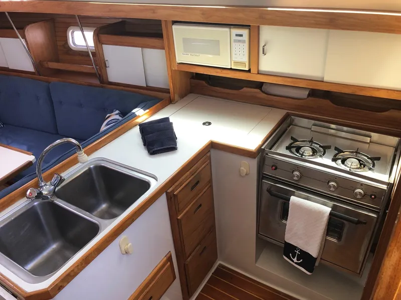 Slide: The Image of 1993 Catalina 34 MK 1.5 yacht interior with kitchen, stove, sink, and microwave. - 4