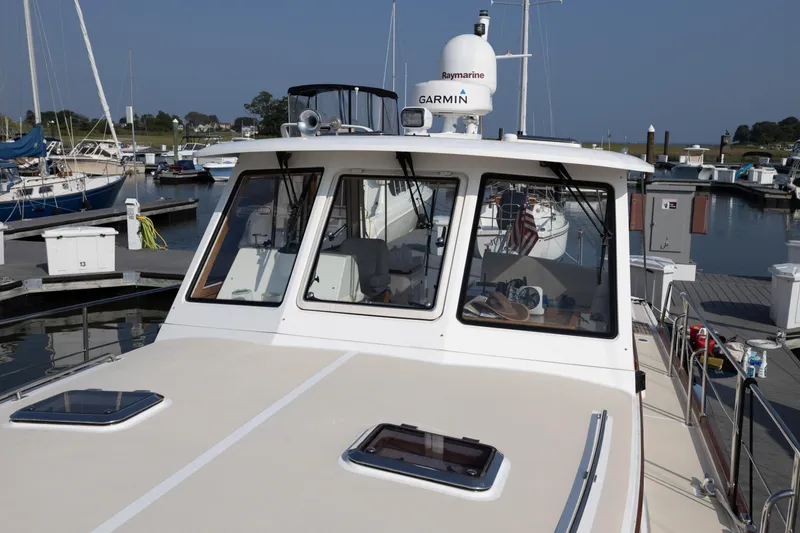 Slide: The Image of 2005 Grand Banks Eastbay 43 HX yacht docked at a marina, featuring navigation equipment. - 10