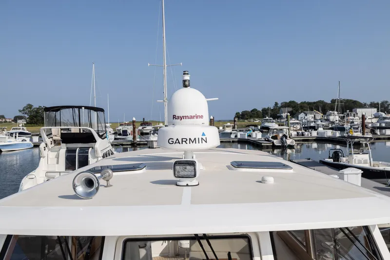 Slide: The Image of 2005 Grand Banks Eastbay 43 HX yacht docked in a marina, featuring Garmin and Raymarine equipment. - 15