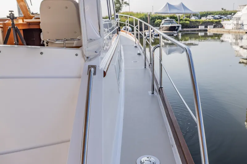 Slide: The Image of 2005 Grand Banks Eastbay 43 HX yacht deck with railing, docked at marina. - 16