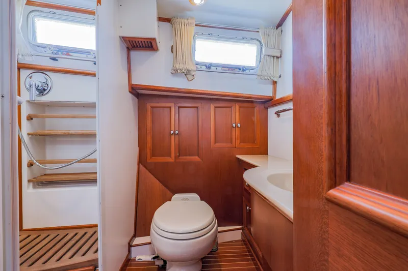Slide: The Image of Luxurious 2005 Grand Banks Eastbay 43 HX yacht bathroom with wooden cabinetry and modern fixtures. - 18