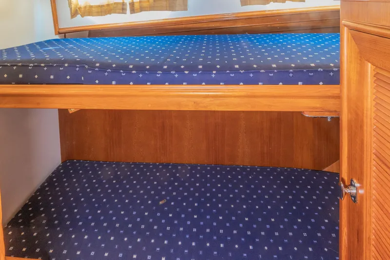 Slide: The Image of Bunk beds with blue patterned mattresses on a 2005 Grand Banks Eastbay 43 HX yacht. - 19