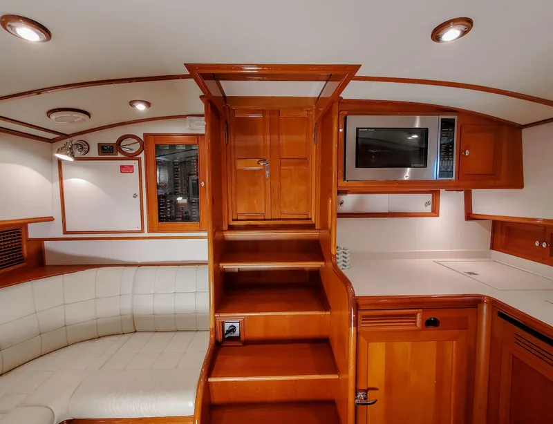 Slide: The Image of 2005 Grand Banks Eastbay 43 HX interior with wooden cabinetry, stairs, and modern amenities. - 20