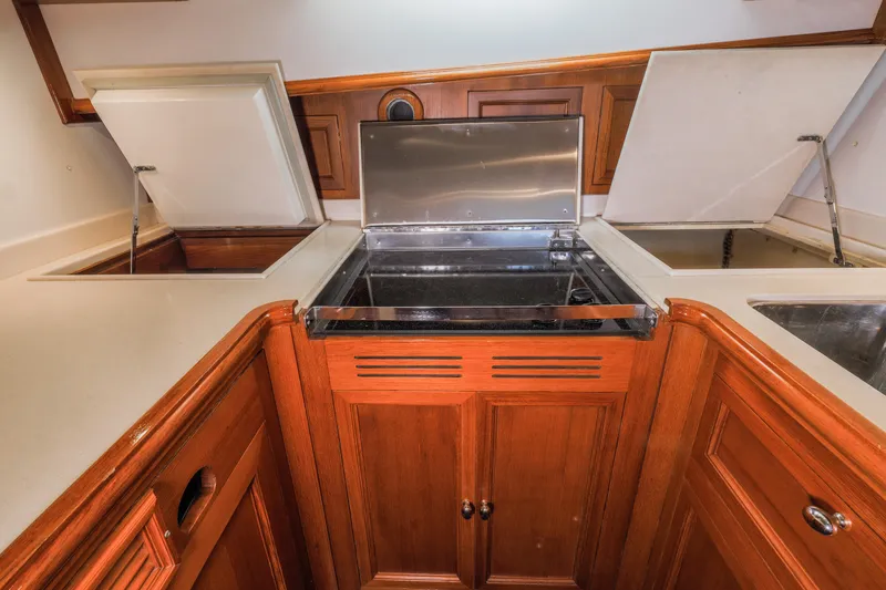Slide: The Image of 2005 Grand Banks Eastbay 43 HX yacht kitchen with wooden cabinetry and stainless steel appliances. - 24