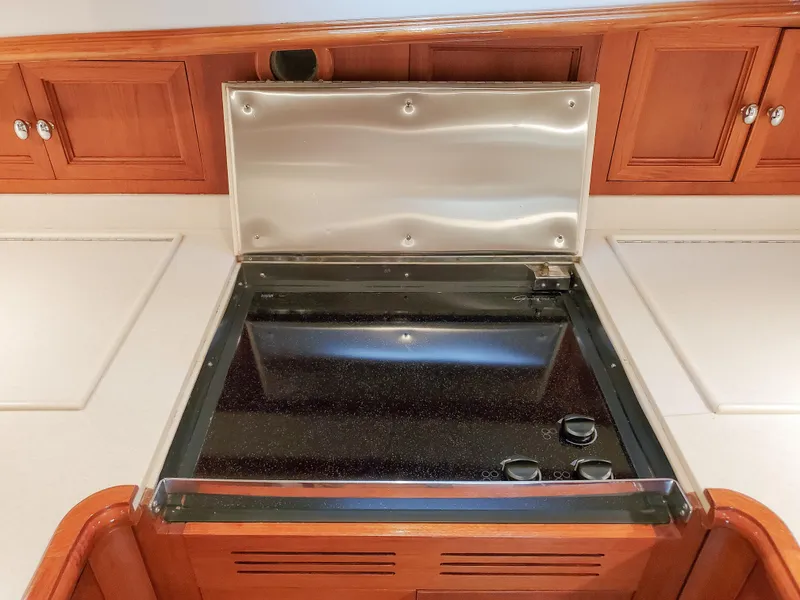 Slide: The Image of Stovetop in 2005 Grand Banks Eastbay 43 HX yacht kitchen, featuring wooden cabinetry. - 25