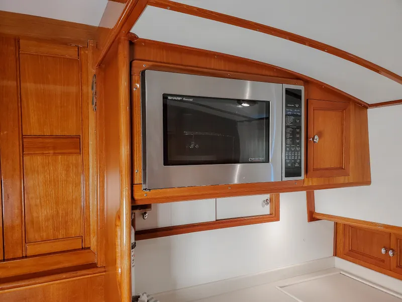 Slide: The Image of Wood-paneled kitchen with built-in microwave on 2005 Grand Banks Eastbay 43 HX yacht. - 29
