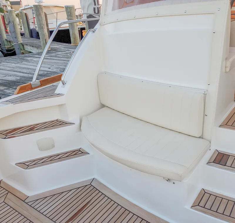 Slide: The Image of 2005 Grand Banks Eastbay 43 HX boat seating area with teak steps and white cushions. - 8