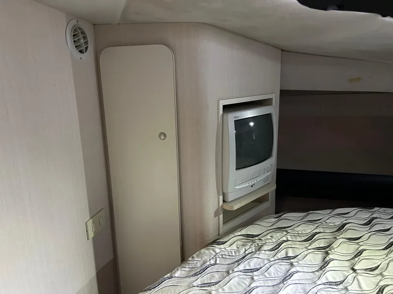 Slide: The Image of 1997 Cruisers Yachts 3575 Esprit cabin interior with TV and patterned bedding. - 16