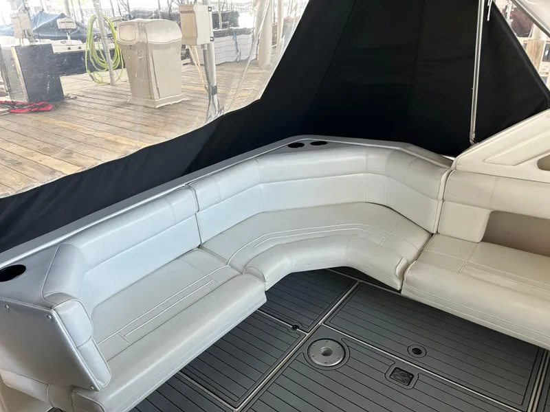 Slide: The Image of 1997 Cruisers Yachts 3575 Esprit interior with white leather seating and wood dock background. - 28