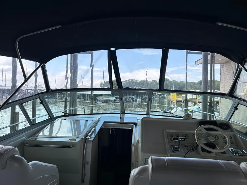 Slide: The Image of 1997 Cruisers Yachts 3575 Esprit cockpit view with steering wheel and marina backdrop. - 7