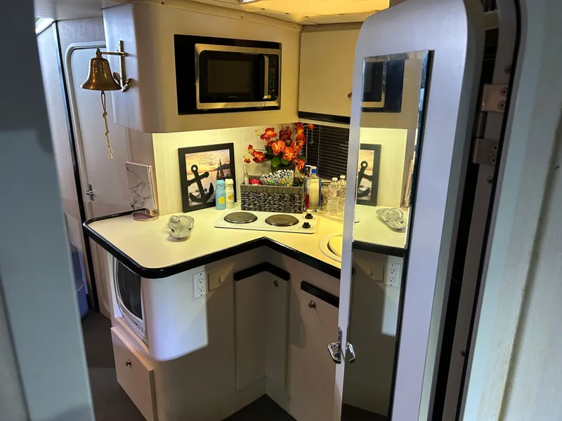 Slide: The Image of 1997 Cruisers Yachts 3575 Esprit interior kitchen with microwave, stove, and decorative items. - 15