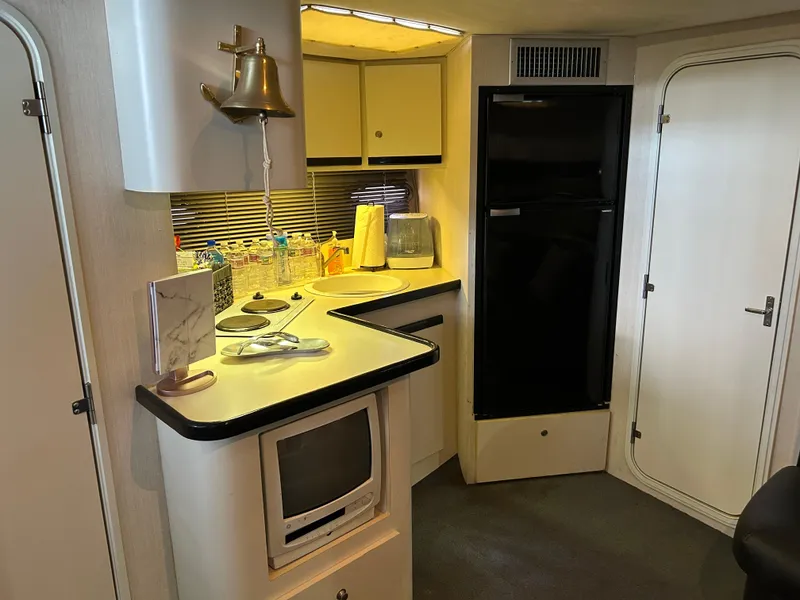 Slide: The Image of Interior of 1997 Cruisers Yachts 3575 Esprit, featuring a compact kitchen area. - 20