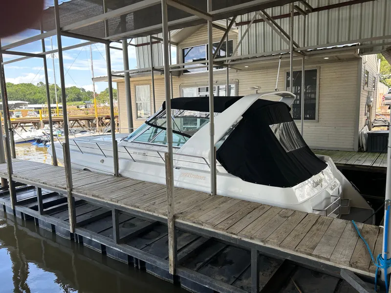 Slide: The Image of 1997 Cruisers Yachts 3575 Esprit docked in a marina with covered seating area. - 3