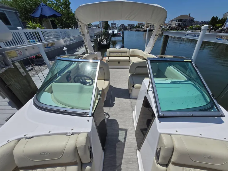 Slide: The Image of 2019 Regal 26 OBX boat with open deck, docked by waterfront homes. - 10