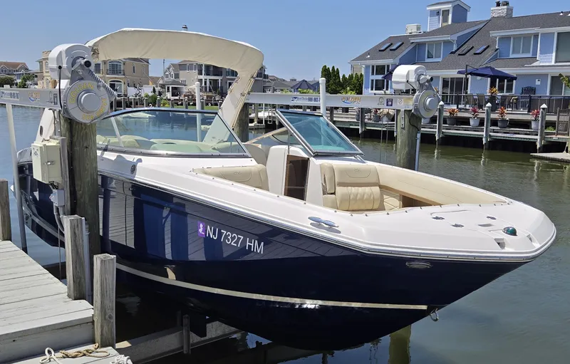 Slide: The Image of 2019 Regal 26 OBX boat docked in a marina with waterfront homes in the background. - 11