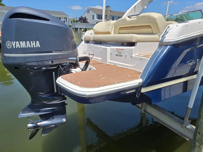 Slide: The Image of 2019 Regal 26 OBX boat with Yamaha outboard motor, docked near waterfront homes. - 12