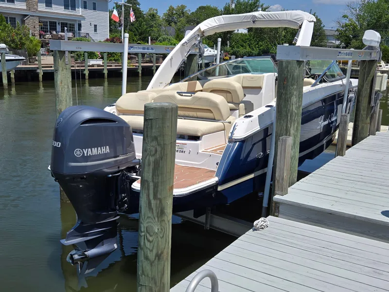 Slide: The Image of 2019 Regal 26 OBX boat docked with Yamaha outboard motor, featuring beige seating. - 3