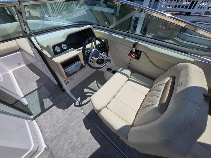 Slide: The Image of 2019 Regal 26 OBX boat interior with steering wheel and beige seating. - 5