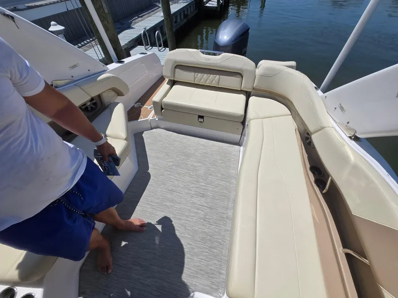 Slide: The Image of 2019 Regal 26 OBX boat interior with beige seating and a person standing. - 6