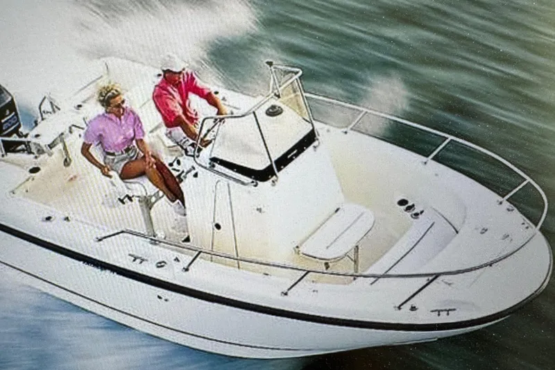 Slide: The Image of 1999 Boston Whaler 21 Outrage boat cruising on water with two passengers. - 0
