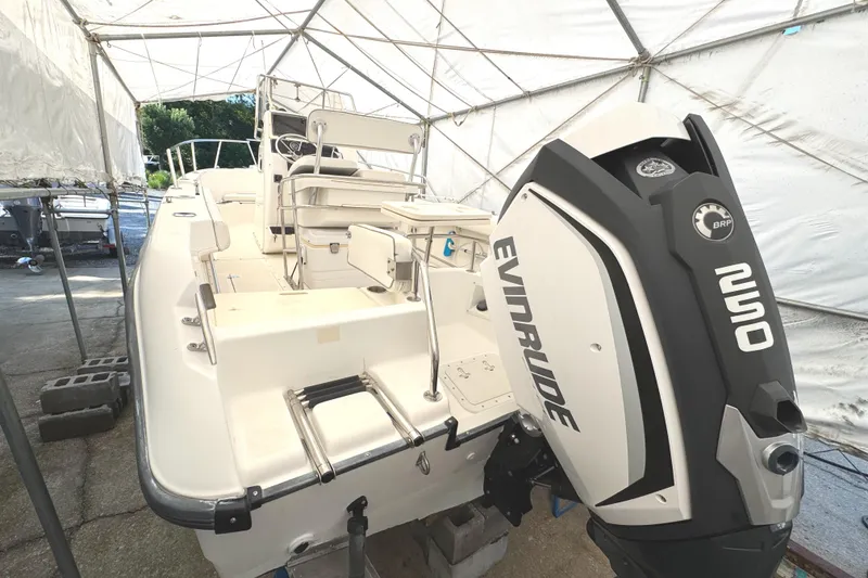 Slide: The Image of 1999 Boston Whaler 21 Outrage boat with Evinrude engine in a covered storage area. - 2