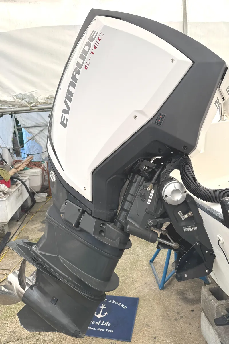 Slide: The Image of Outboard motor on a 1999 Boston Whaler 21 Outrage boat, featuring Evinrude E-TEC engine. - 20