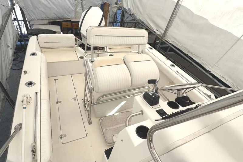 Slide: The Image of 1999 Boston Whaler 21 Outrage boat interior with white seating and steering console. - 5