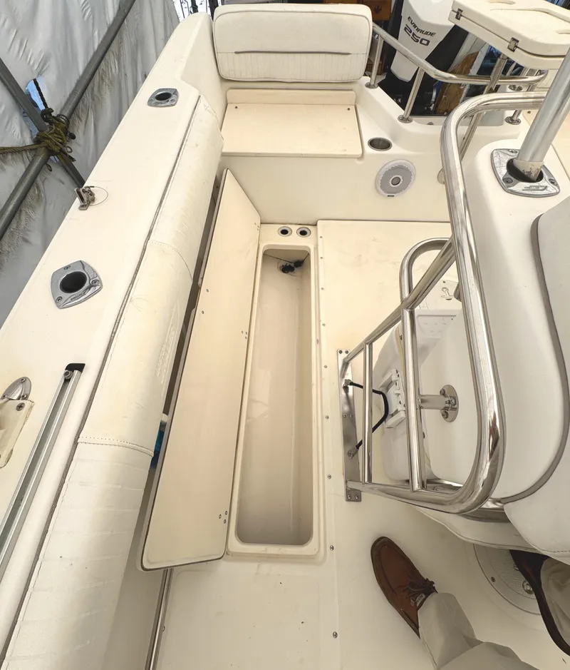 Slide: The Image of 1999 Boston Whaler 21 Outrage boat interior with open storage compartment and seating. - 8