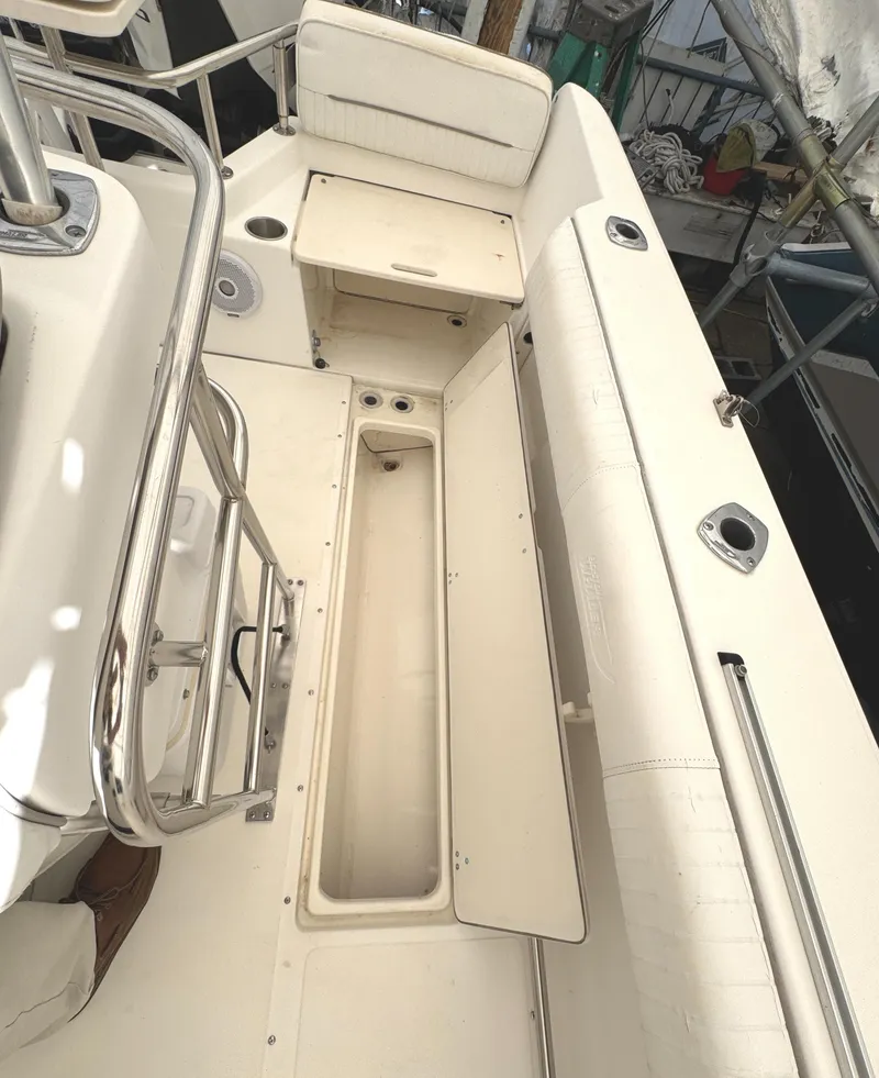 Slide: The Image of 1999 Boston Whaler 21 Outrage boat interior with storage compartments and seating. - 9