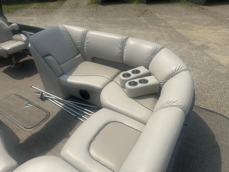 Slide: The Image of 2016 Manitou 25 Legacy SRS boat interior with plush seating and cup holders. - 11