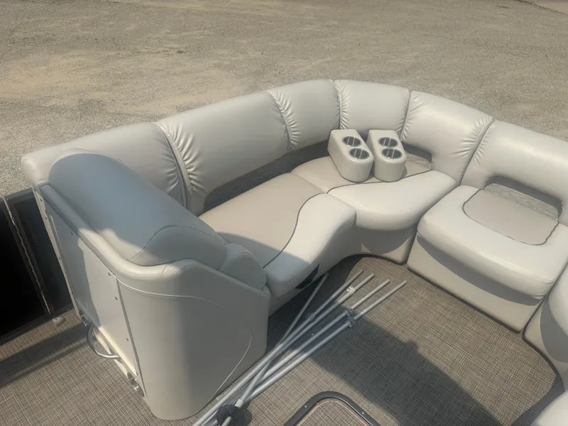 Slide: The Image of 2016 Manitou 25 Legacy SRS boat interior with plush seating and cup holders. - 13