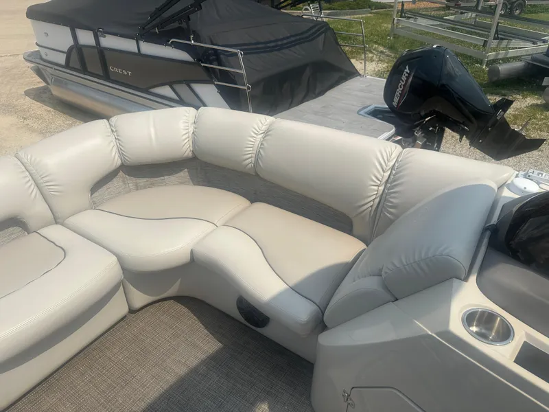 Slide: The Image of 2016 Manitou 25 Legacy SRS pontoon boat with beige seating and Mercury outboard motor. - 14