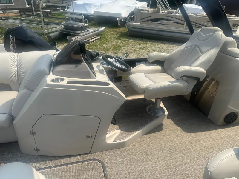 Slide: The Image of 2016 Manitou 25 Legacy SRS boat interior with captain's chair and control console. - 15