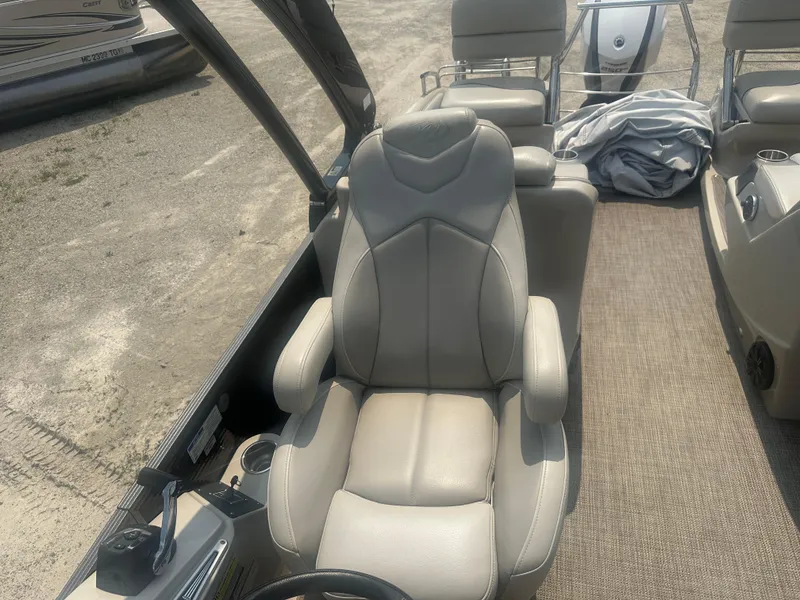 Slide: The Image of Captain's seat on 2016 Manitou 25 Legacy SRS pontoon boat, featuring beige upholstery. - 19