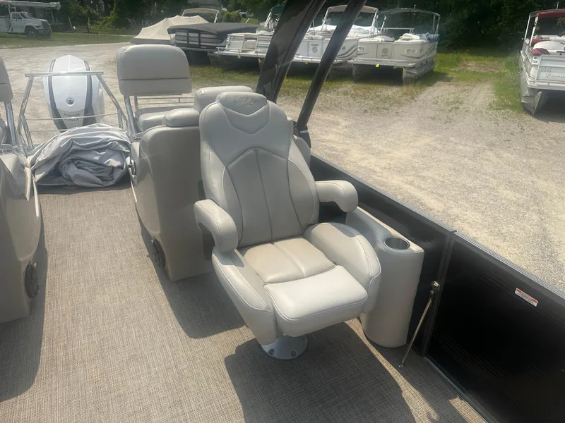 Slide: The Image of 2016 Manitou 25 Legacy SRS boat interior with luxurious seating and cup holder. - 21