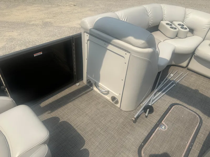 Slide: The Image of 2016 Manitou 25 Legacy SRS boat interior with plush seating and cup holders. - 22