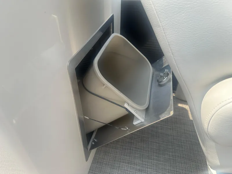 Slide: The Image of Hidden compartment with a small bin in a 2016 Manitou 25 Legacy SRS boat. - 25