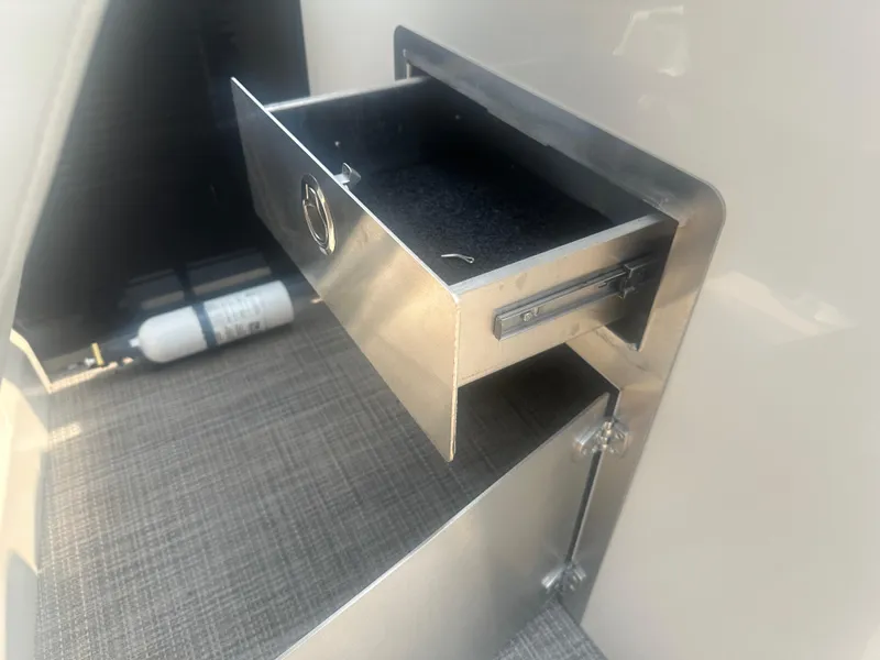 Slide: The Image of Open storage drawer in 2016 Manitou 25 Legacy SRS boat interior. - 26