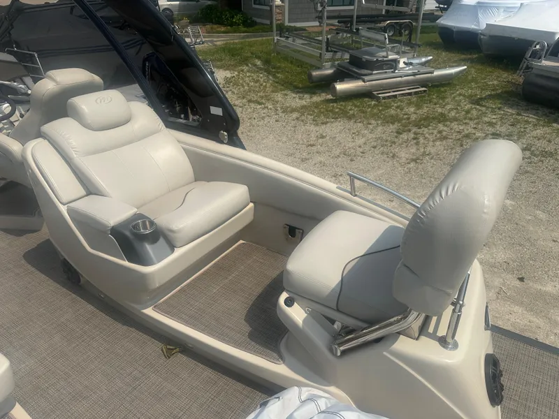 Slide: The Image of 2016 Manitou 25 Legacy SRS boat interior with plush seating and cup holder. - 5