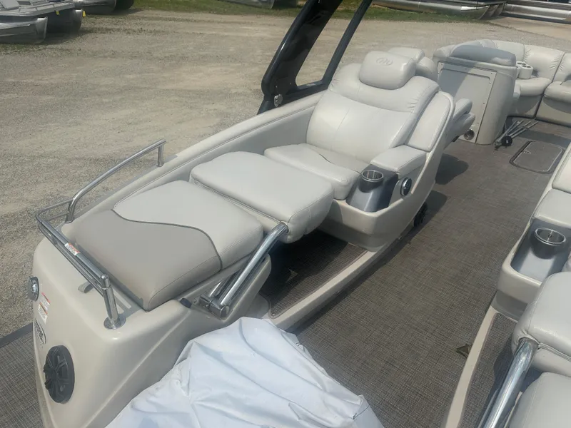 Slide: The Image of 2016 Manitou 25 Legacy SRS boat interior with luxurious seating and cup holders. - 8