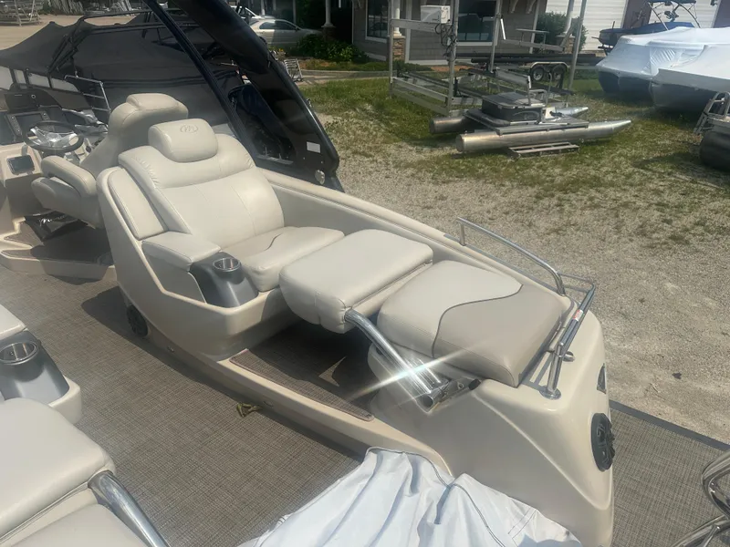 Slide: The Image of 2016 Manitou 25 Legacy SRS boat with luxurious seating and cup holders. - 9