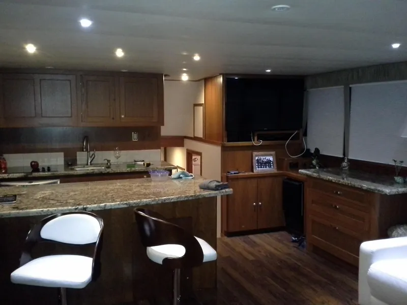 Slide: The Image of Luxurious interior of 2001 Darling Yachts 62 Enclosed Bridge with modern kitchen and seating. - 10