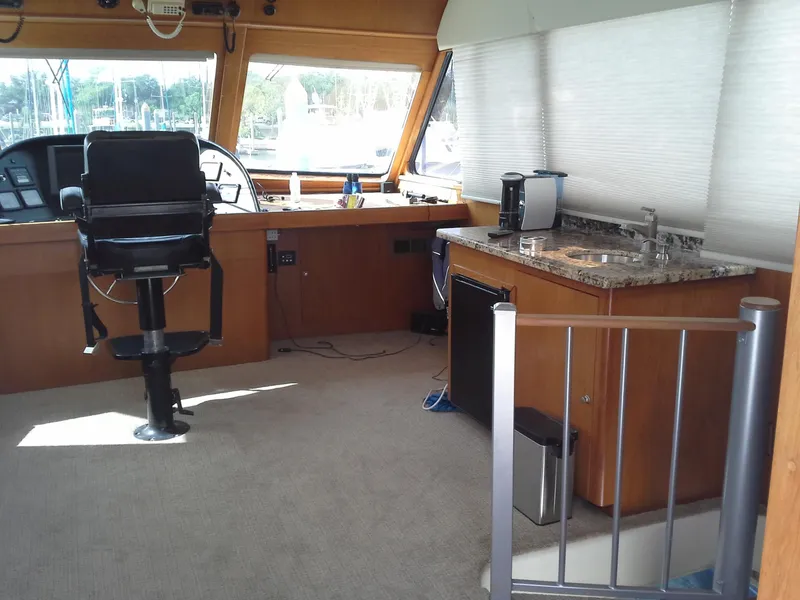 Slide: The Image of Interior of 2001 Darling Yachts 62 Enclosed Bridge with helm and kitchenette. - 11